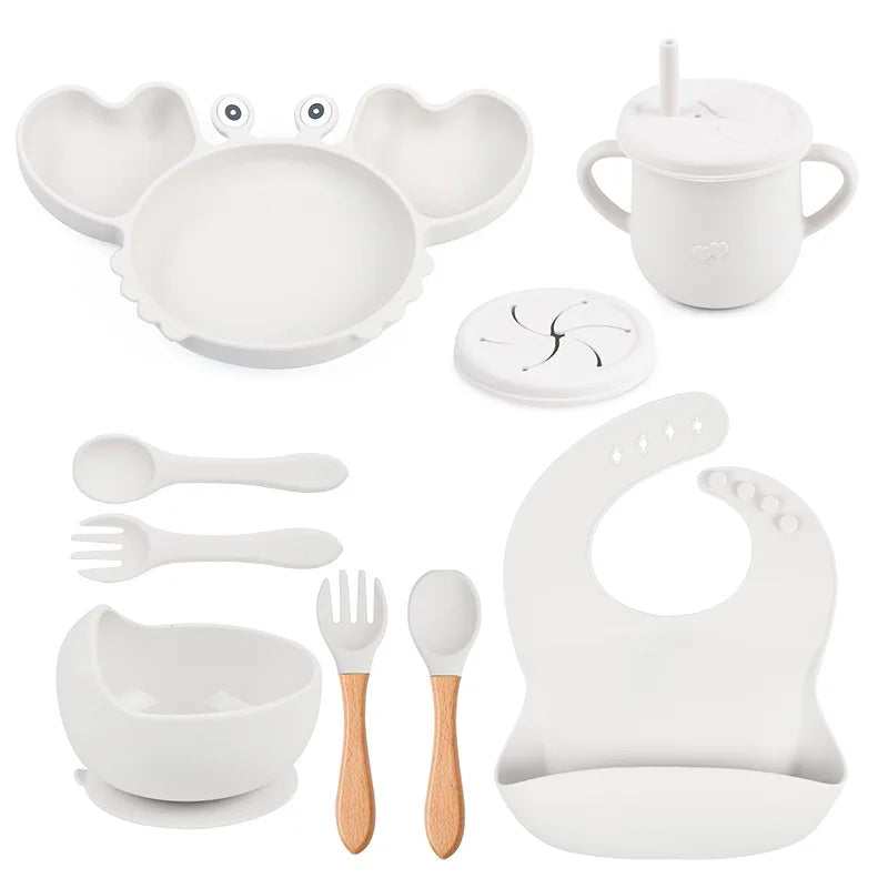 white variant of 9-piece best silicone baby feeding set including a non-slip suction bowl, plate, spoon, waterproof bib, cup, and crab-shaped dishes. BPA-free and designed for children aged 7-36 months, this dinnerware set ensures safe and mess-free mealtime.